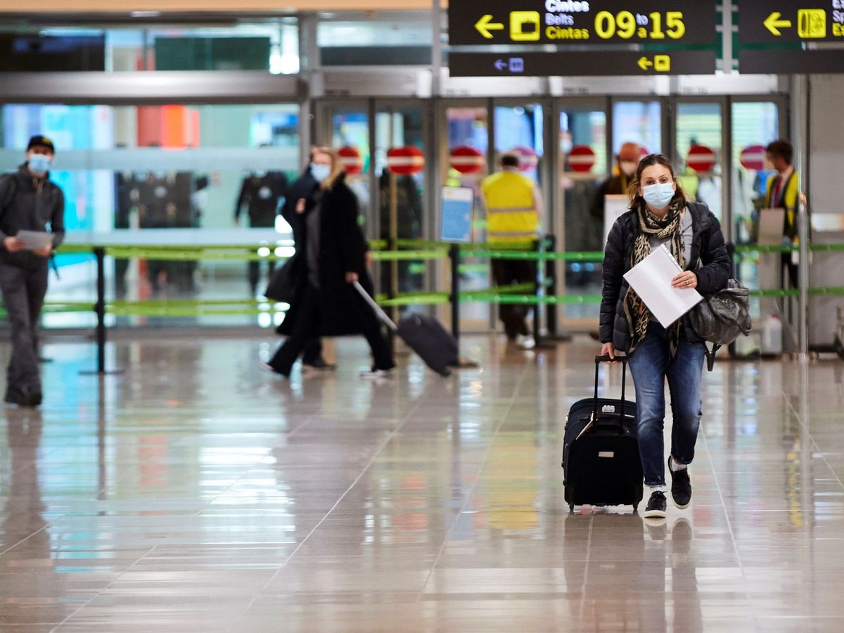 Foto: Una viajera con mascarilla a su llegada al aeropuerto de Barcelona (EFE)