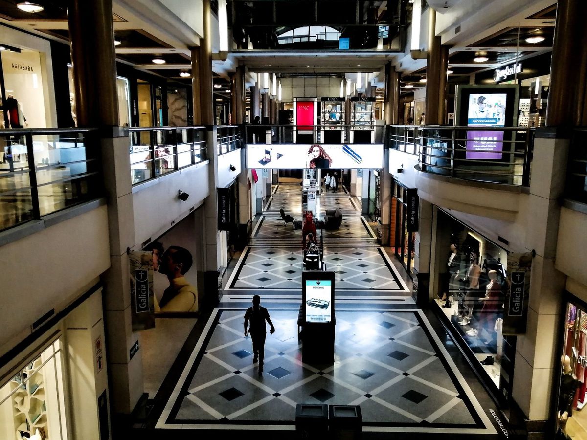 Foto: Un hombre pasea por un centro comercial con los comercios cerrados. (EFE)