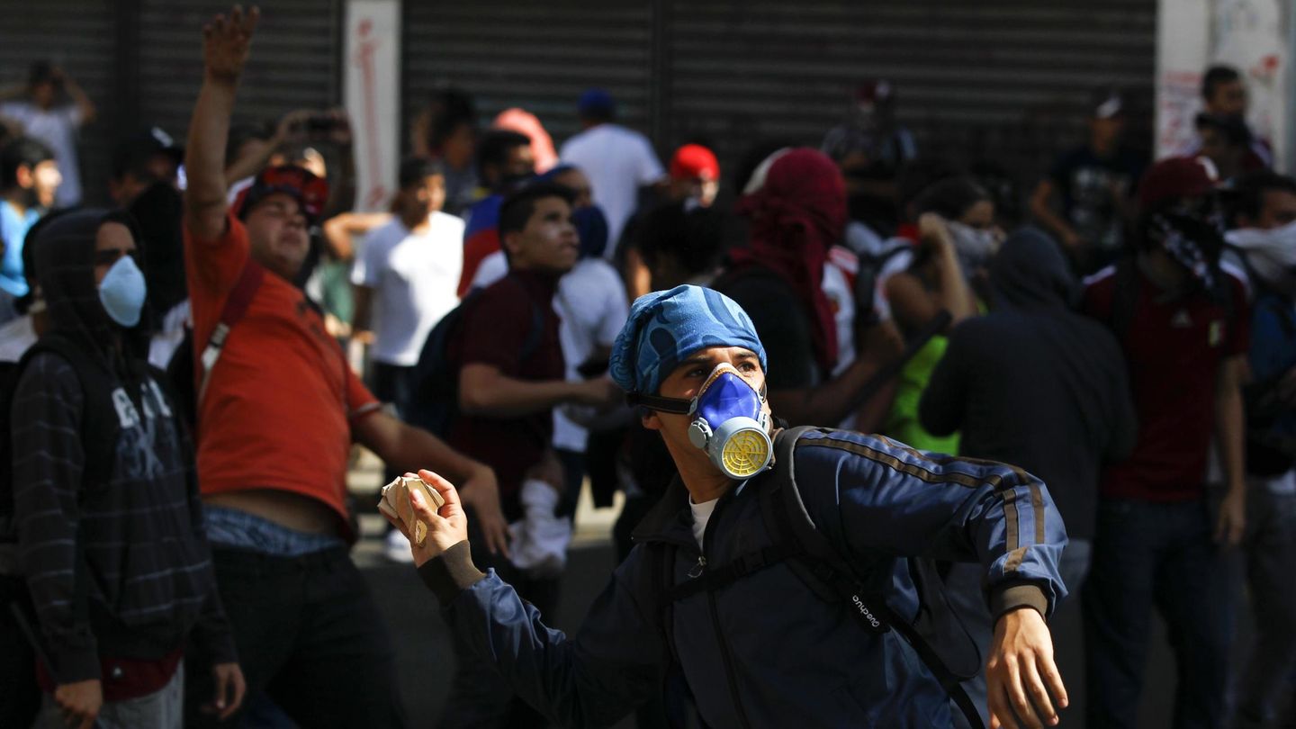 Un opositor arroja piedras a la Policía durante la protesta en Caracas (Reuters).