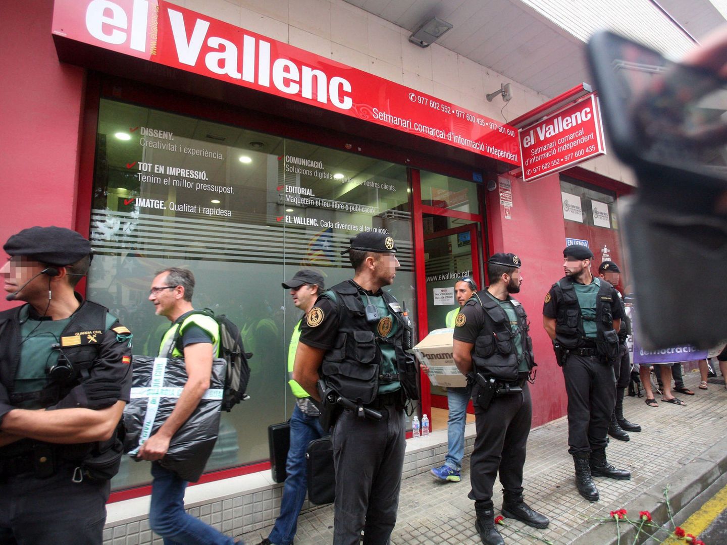 Efectivos de la guardia civil transportan cajas a su salida del semanario 'El Vallenc'. (EFE)