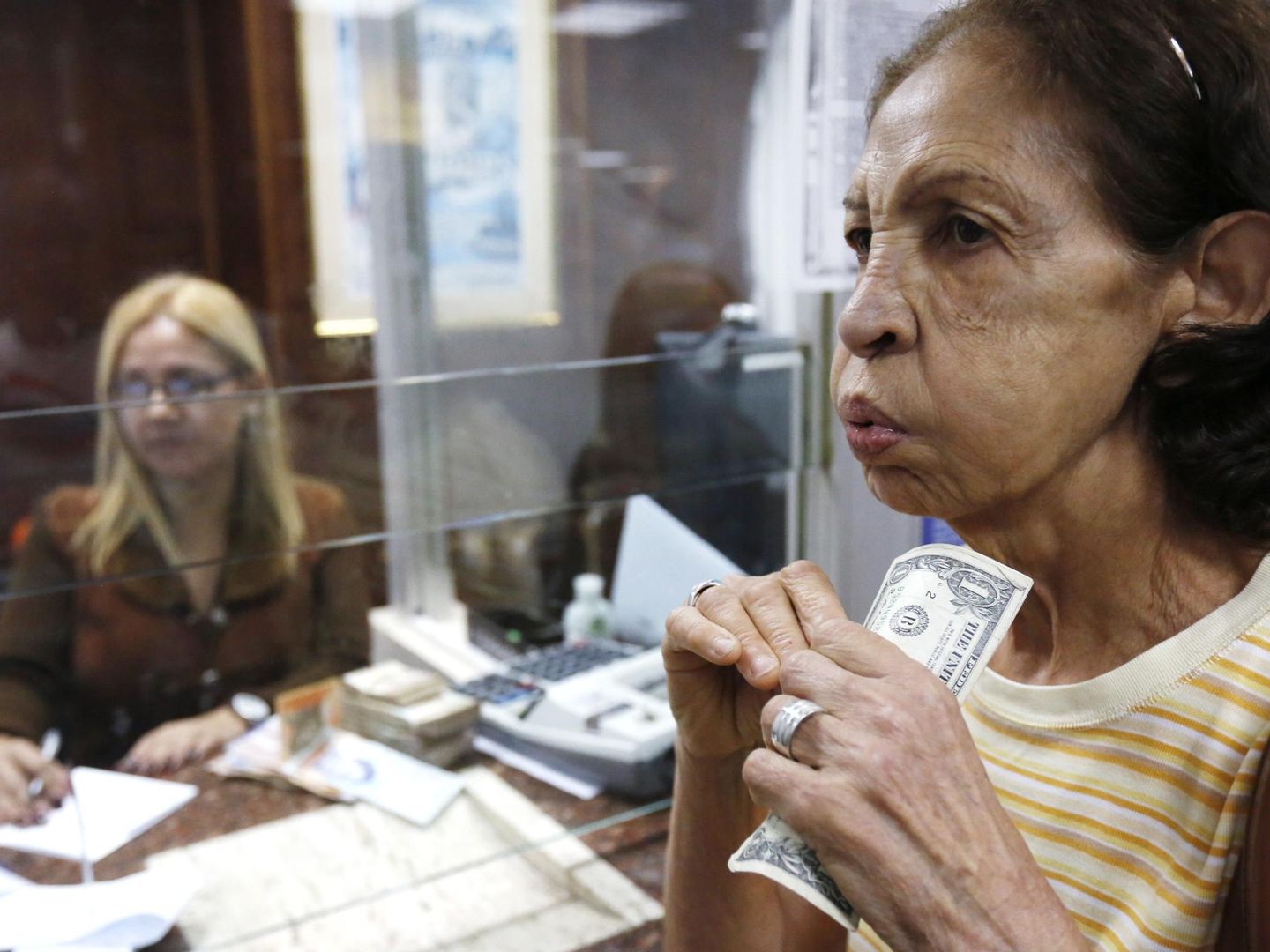 Una mujer cambia dólares por bolívares en Caracas, en febrero de 2015. (Reuters)