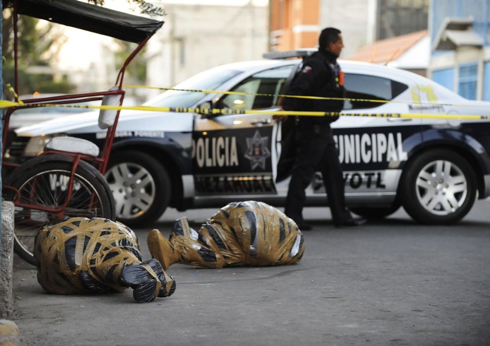 Foto: Un agente sale de una zona acotada cerca de dos cadáveres envueltos en plástico en Nezahualcóyotl, estado de México. (Reuters)