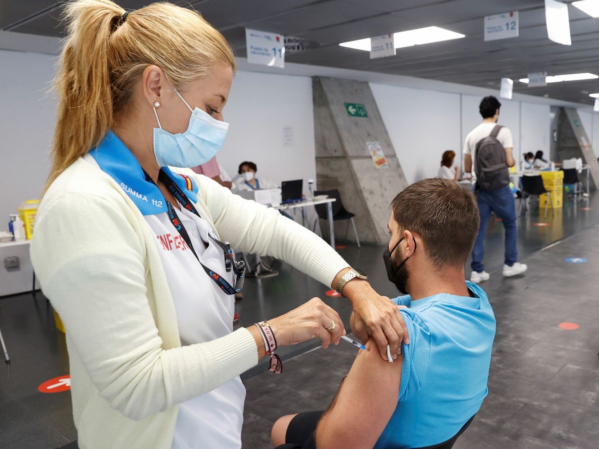 Foto: Un hombre recibe la vacuna contra el covid en el punto de vacunación masivo instalado en el Wizink Center de Madrid. (EFE) 