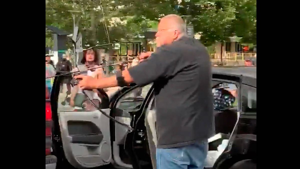 Un hombre amenaza con un arco y flechas a una multitud de manifestantes
