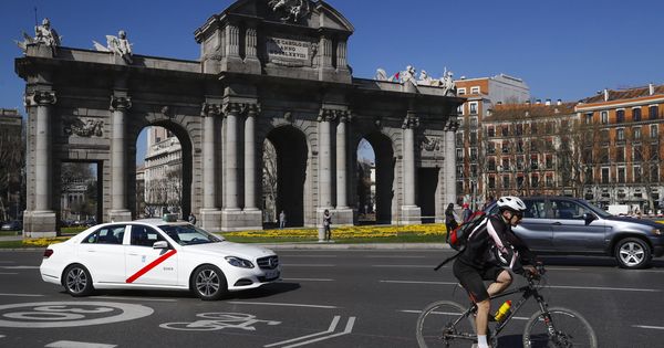 Foto: Un ciclista, a su paso por la Puerta de Alcalá. (EFE)
