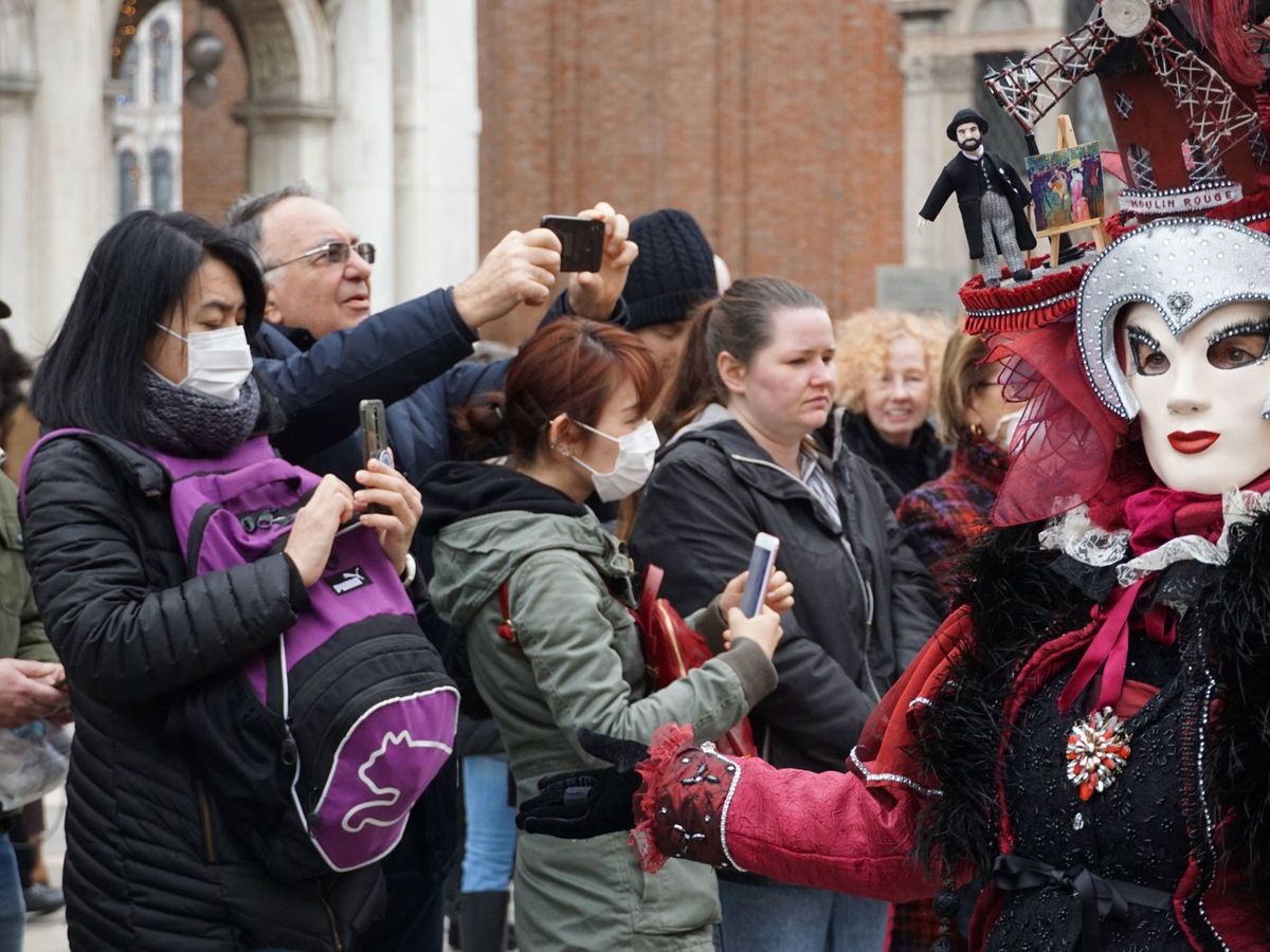 Foto: Turistas con máscaras protectoras visitan la Plaza de San Marcos, el lunes en Venecia (Italia). (EFE)