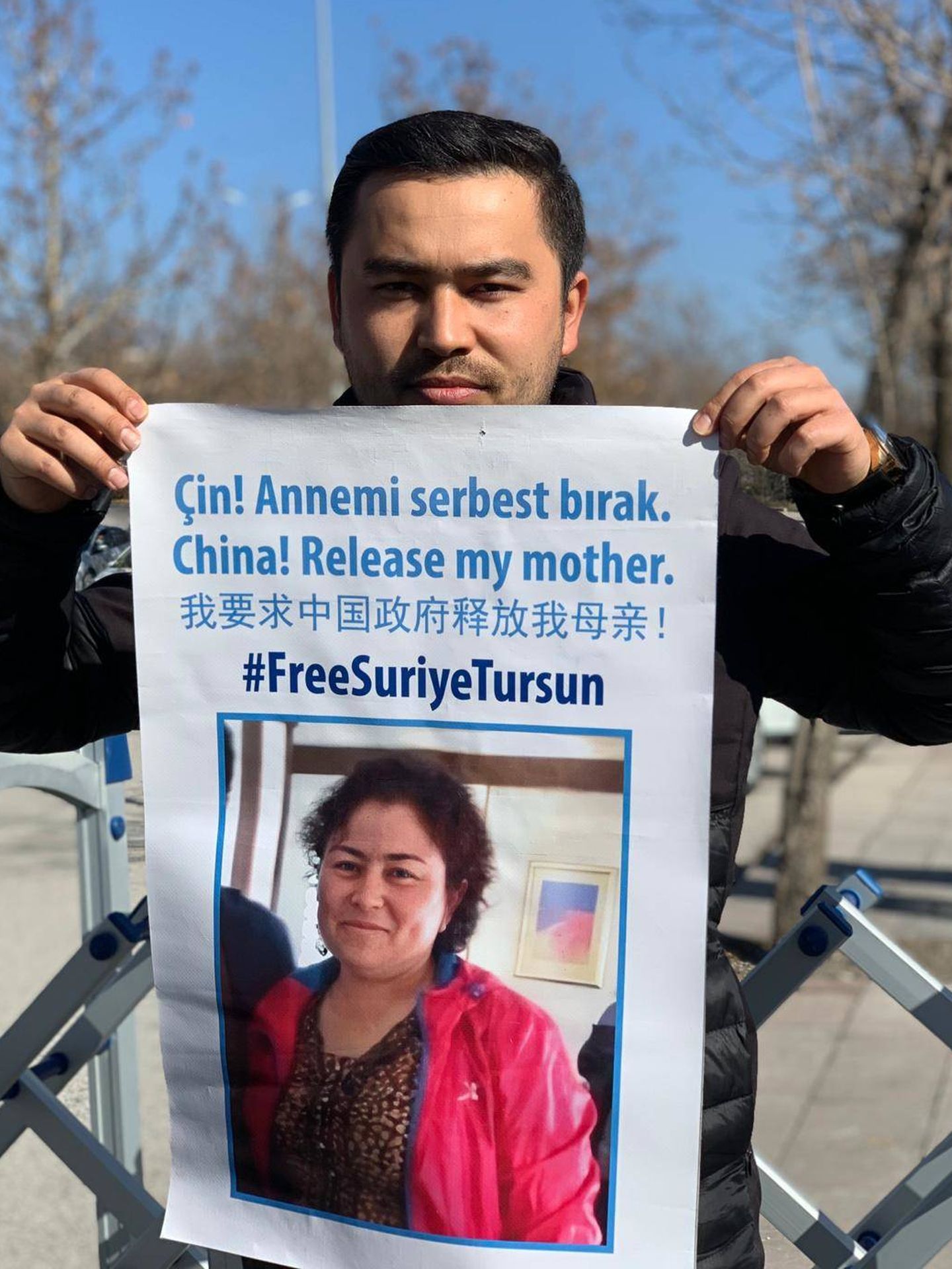 Jevlan Shirmemmet sostiene un cartel en el que pide por la liberación de su madre en una protesta en Turquía