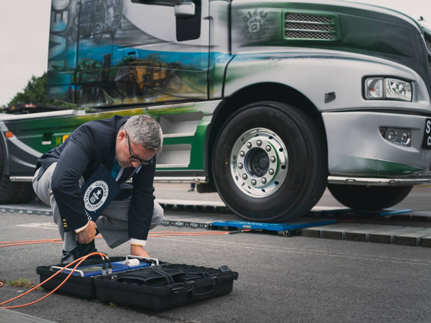 Uno de los supervisores del Guinness World Records pesa con precisión un camión.