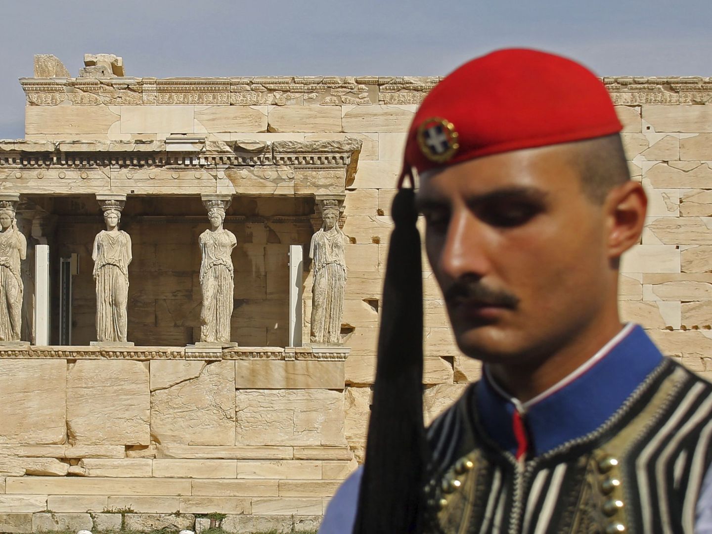 Un miembro de la Guardia Presidencial permanece en guardia frente al templo Erecteión en la Acrópolis. (EFE)