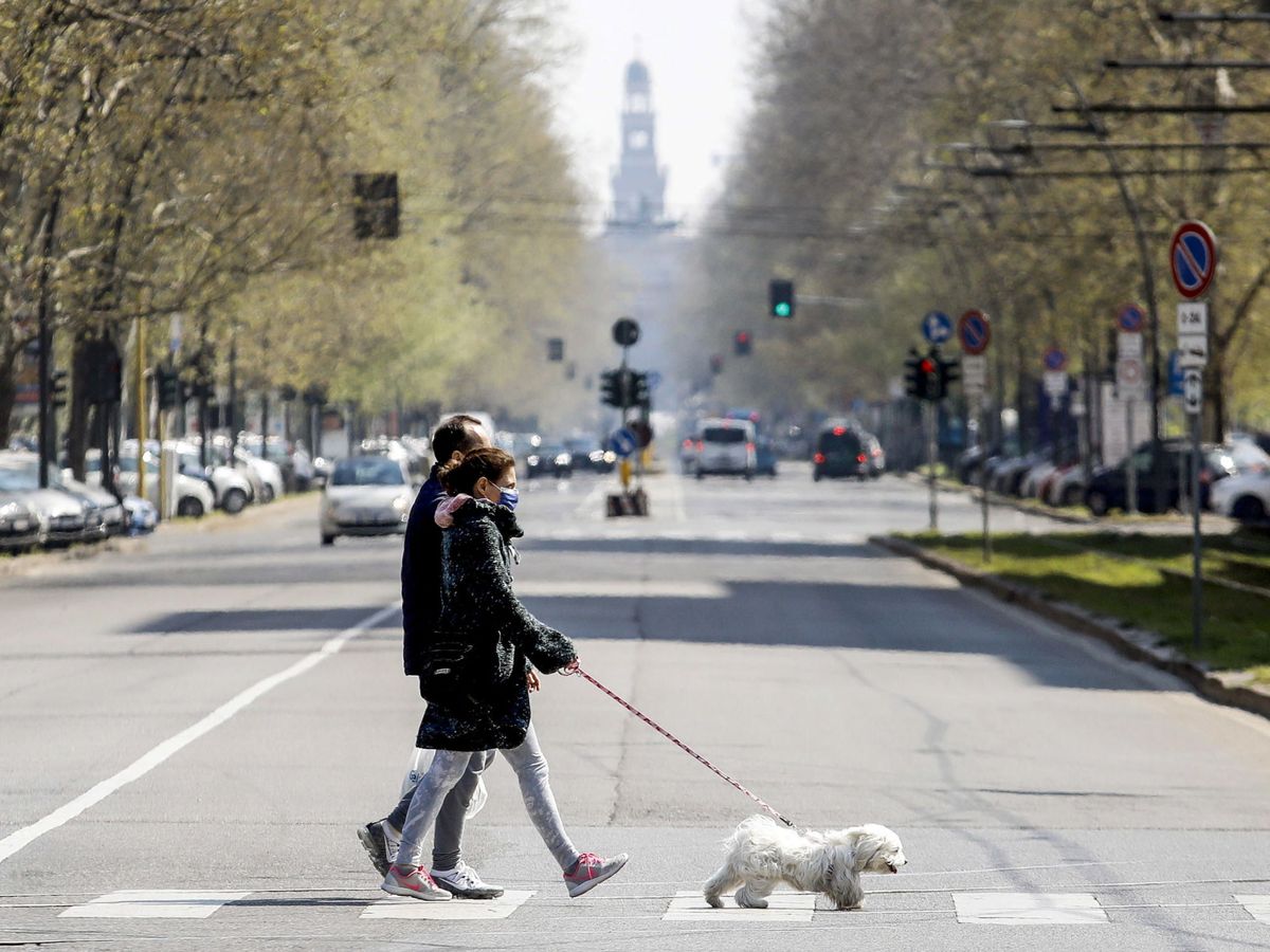 Foto: Dos personan pasean a su perro en Milán. (EFE)