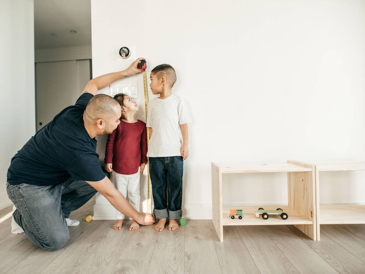 Foto: Un padre mide a sus hijos. (iStock)