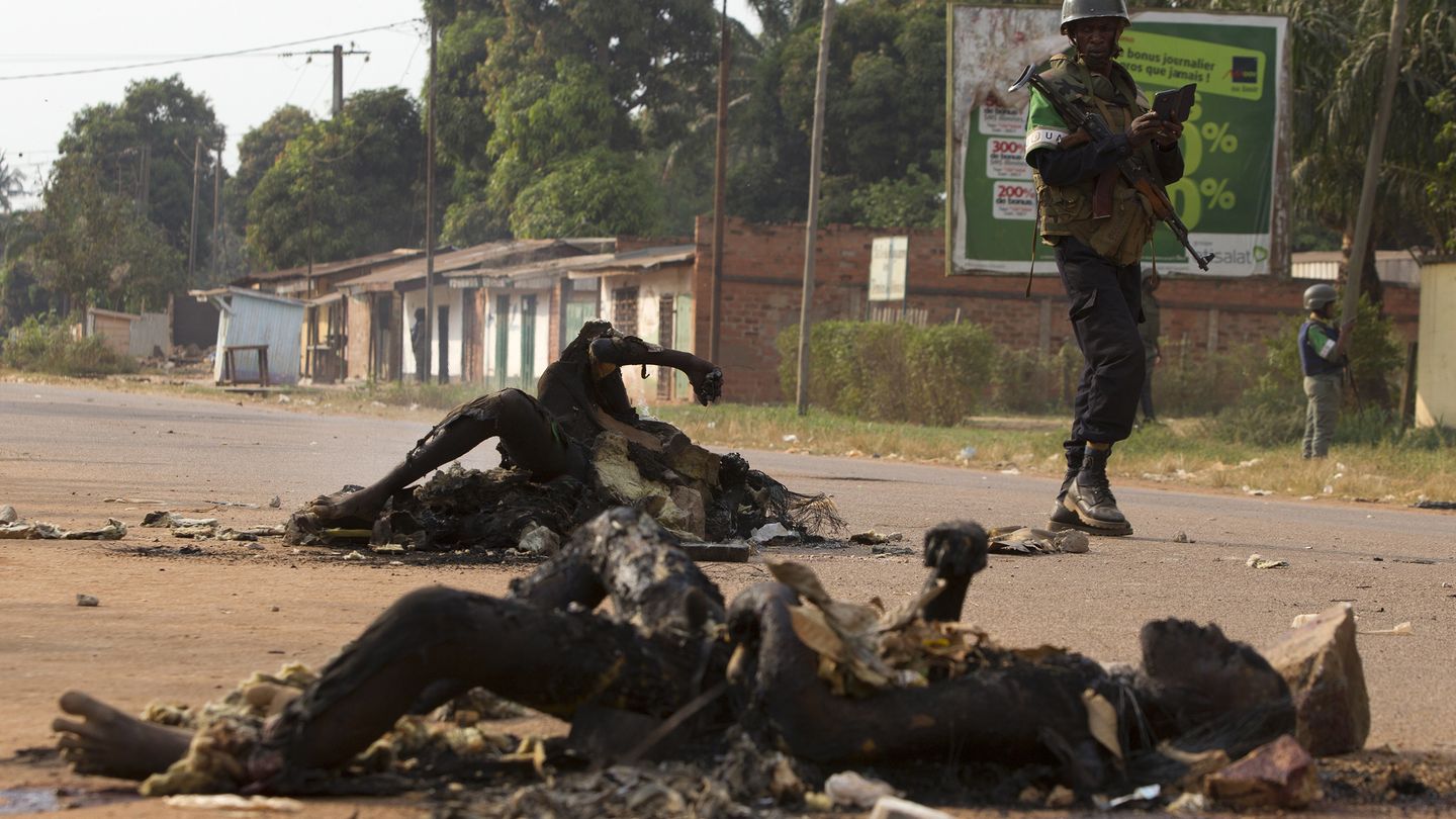 Un soldado de la Unión Africana ante los cuerpos de dos musulmanes en Bangui (Reuters).