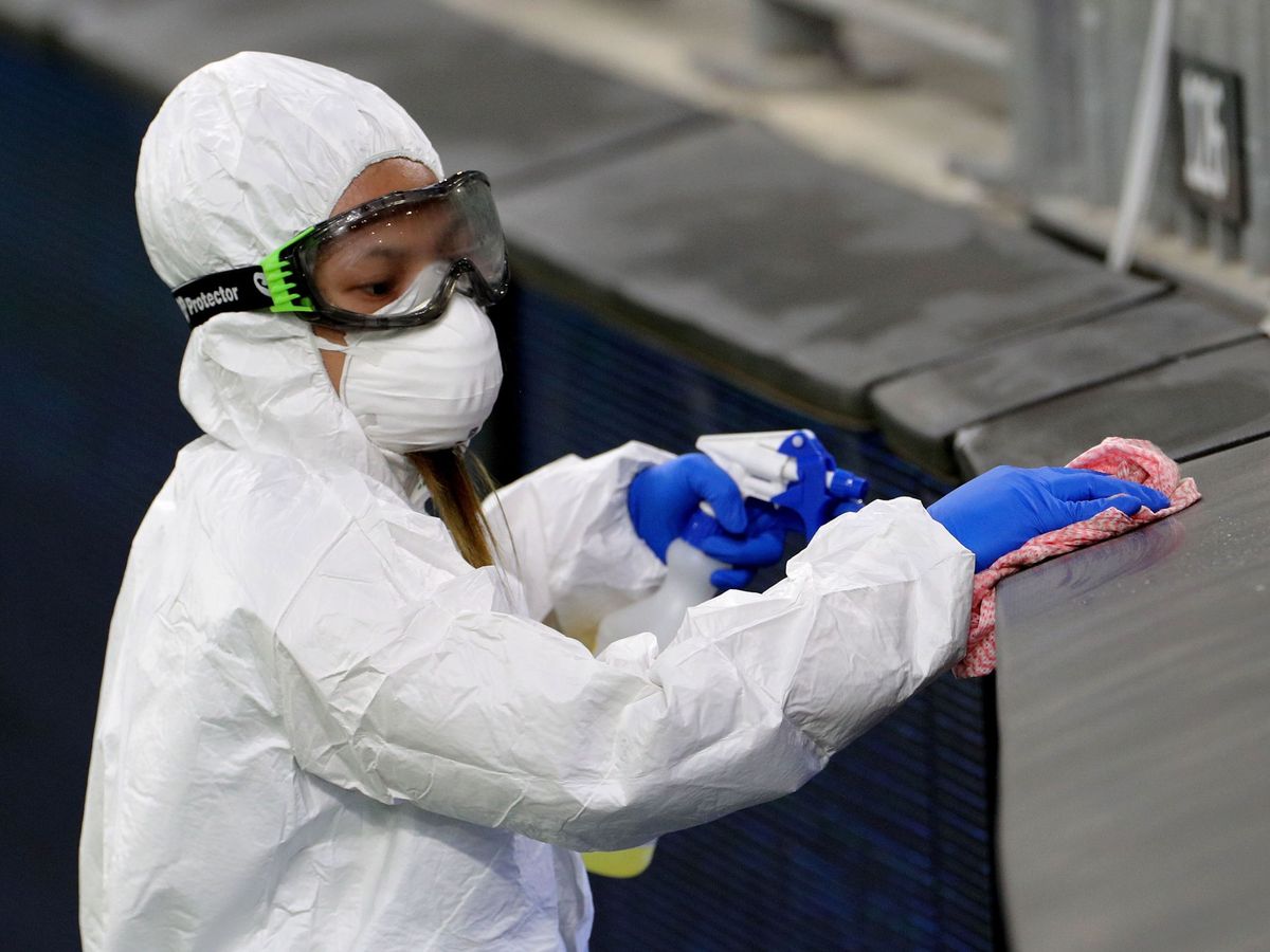 Foto: Una trabajadora desinfectando las gradas de un campo de futbol. (EFE)
