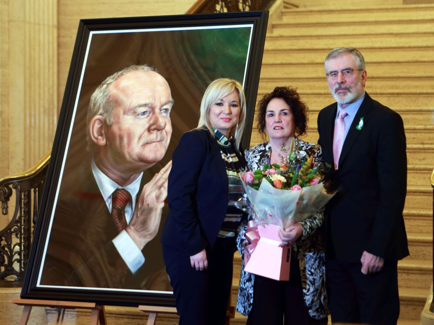 La número dos del Sinn Féin, Michelle O'Neill, Bernadette Canning, viuda del exministro principal norirlandés y exmiembro del IRA, y el líder del Sinn Fein, Gerry Adams, en la presentación del retrato de McGuinness. (EFE/Paul MacErlane)