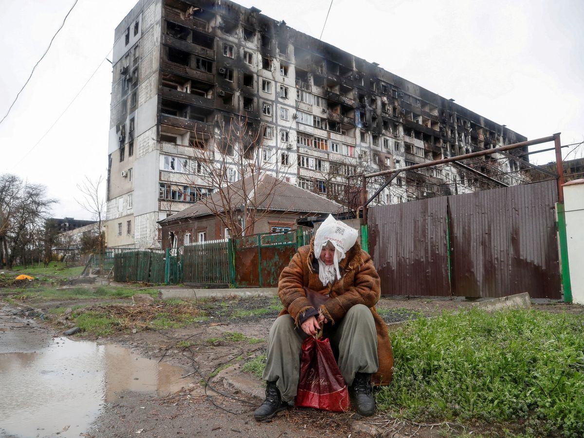 Foto: Una mujer frente a un edificio bombardeado en Mariúpol. (Reuters/Alexander Ermochenko)