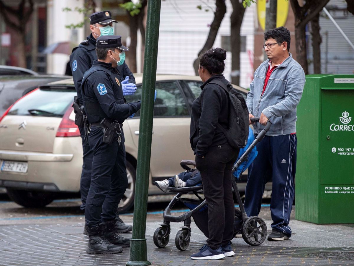Foto: Agentes de la policía local de Murcia informan a una familia de que no puede pasear por la calle, el pasado 16 de marzo. (EFE)