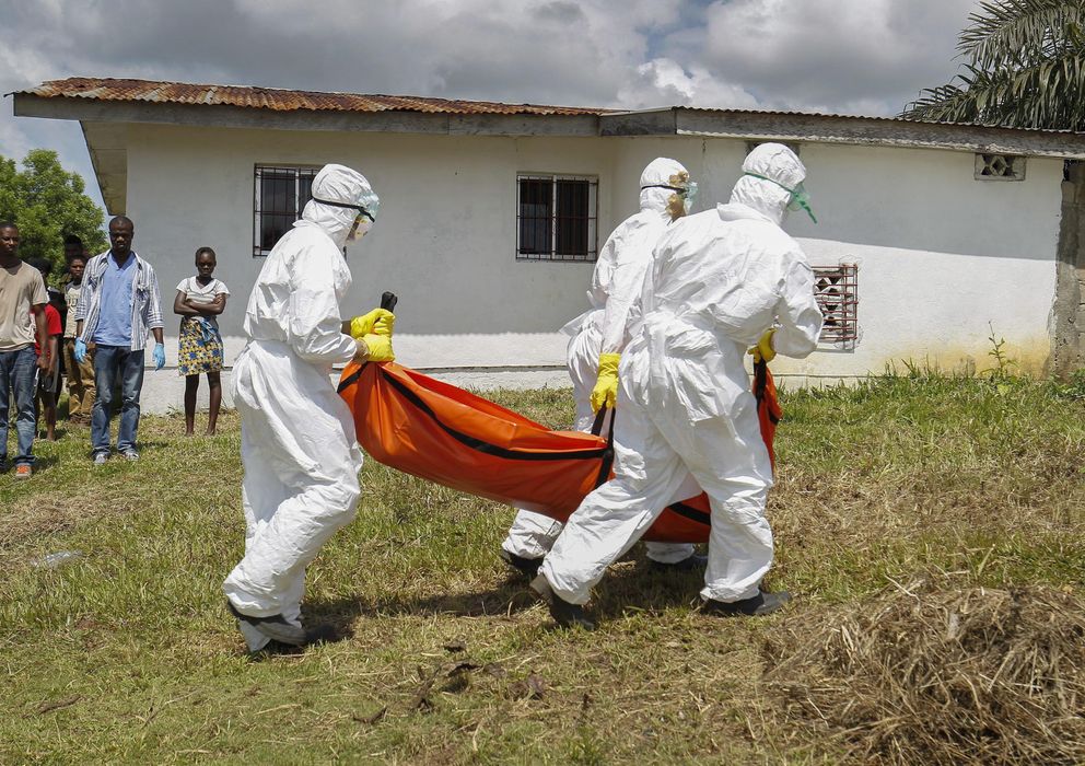 Foto: Voluntarios de Cruz Roja transportan equipos con trajes aislantes a un fallecido por el virus del Ébola en Libera (Efe)