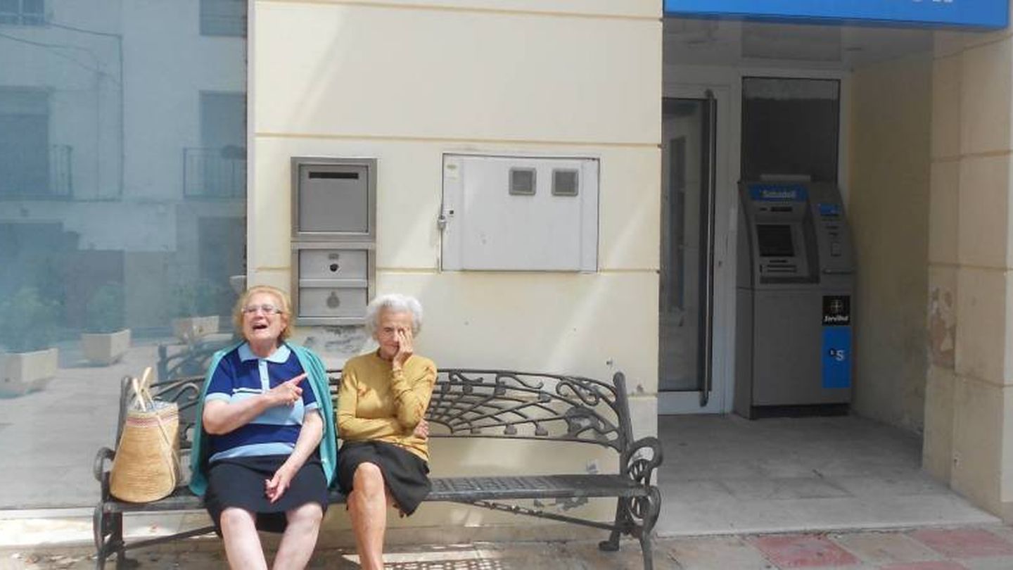 Dos jubiladas, sentadas a las puertas de una oficina cerrada. (V. R.)