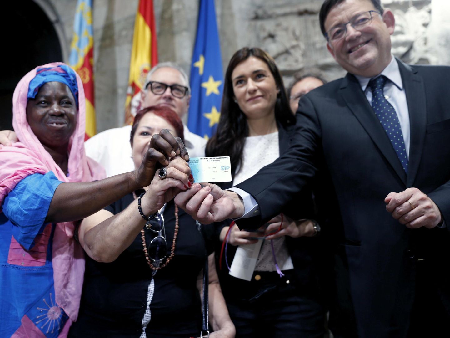 El president de la Generalitat, Ximo Puig (d) y la consellera de Sanidad, Carmen Montón, entre otros, muestran una de las tarjetas sanitarias tras la presentación del Plan de Universalización de la Sanidad en en 2015. (EFE)