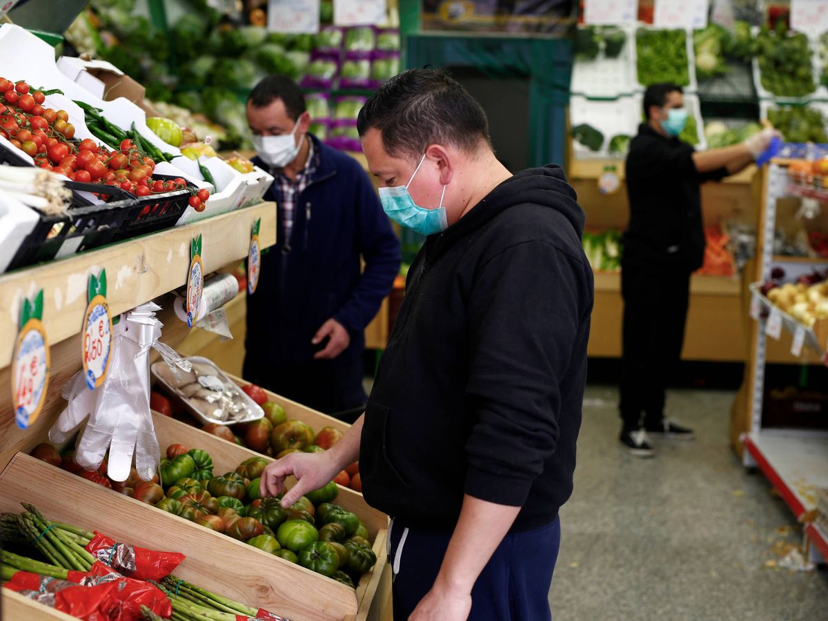 Foto: Varios compradores con mascarilla eligen frutas en un supermercado. (Reuters)