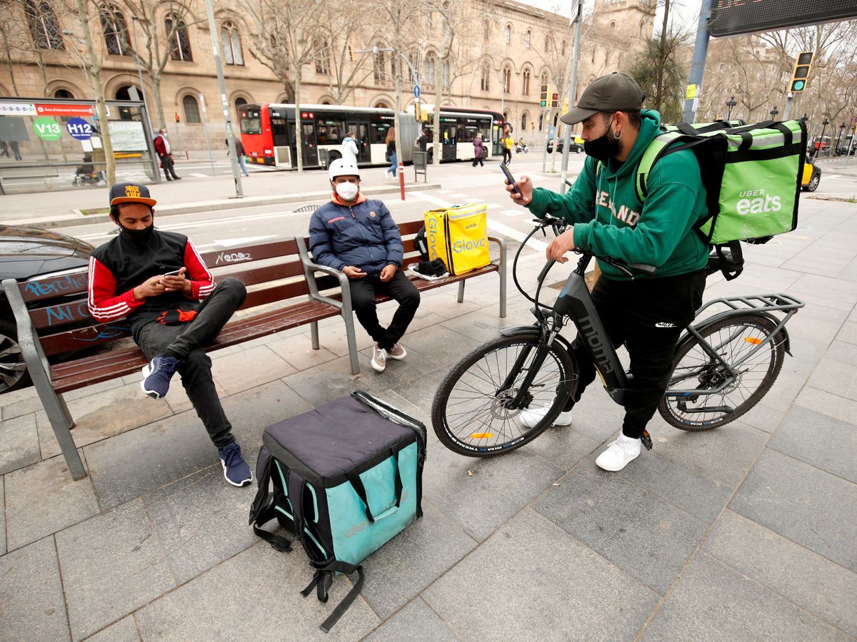 Foto: Repartidores de Glovo, Uber Eats y Deliveroo esperan en Barcelona. (Reuters)