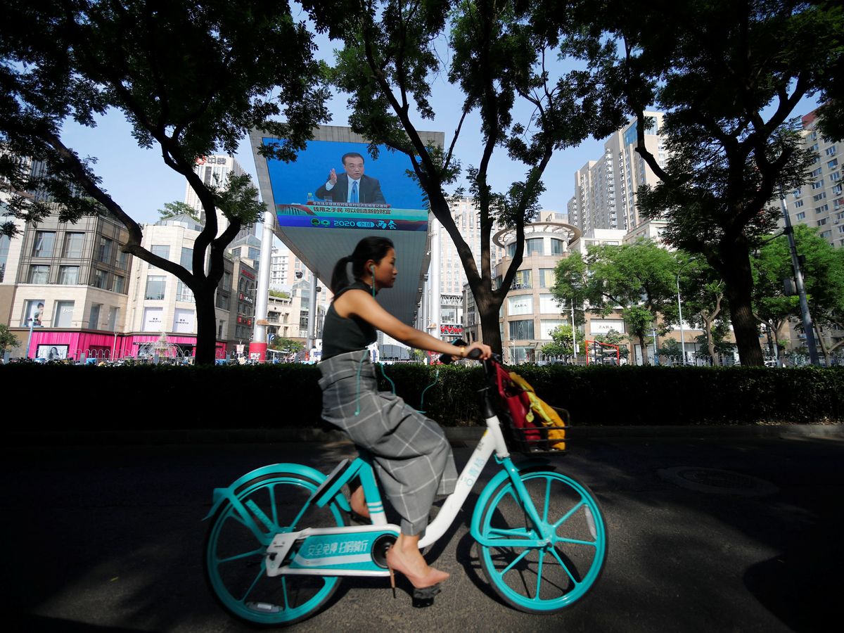 Foto: Una mujer en bicicleta en Beijing. (Reuters)