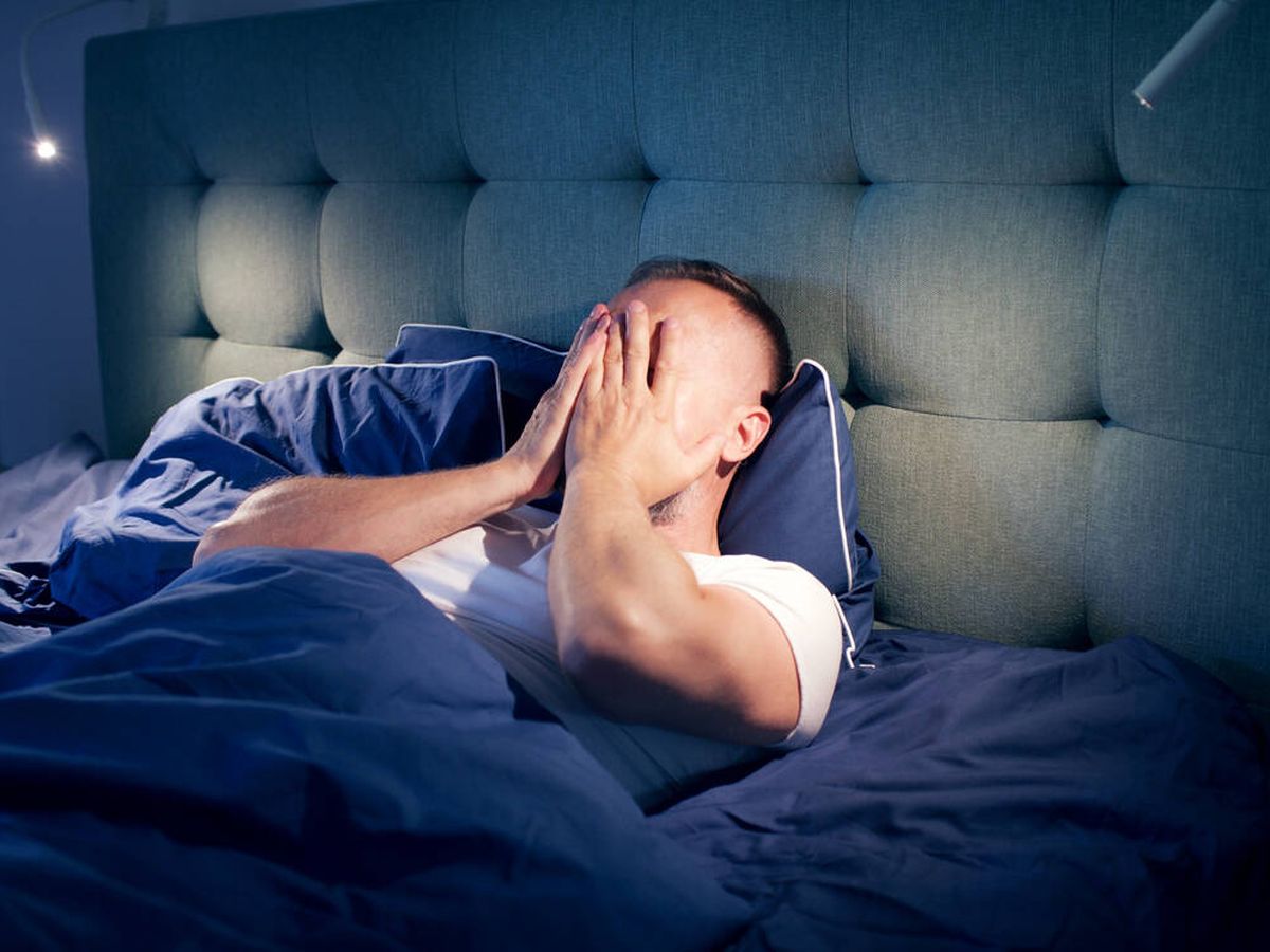 Foto: Un hombre en la cama durmiendo (iStock)