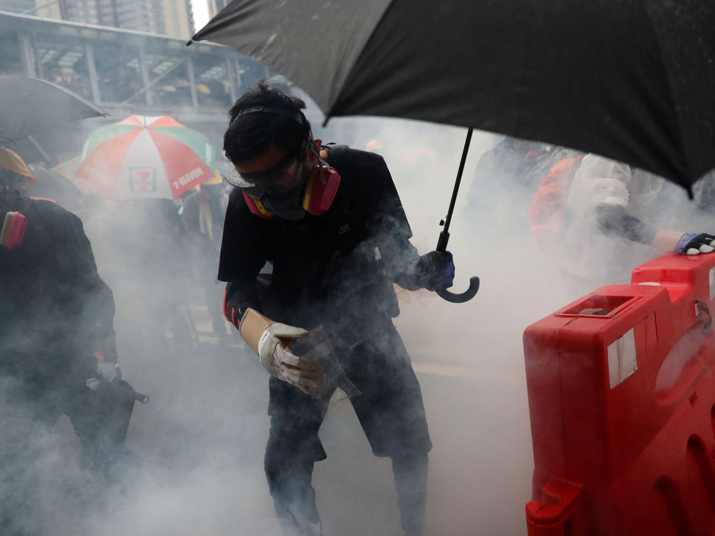 Manifestante protegiéndose con un paraguas de las acciones policiales. (Reuters)