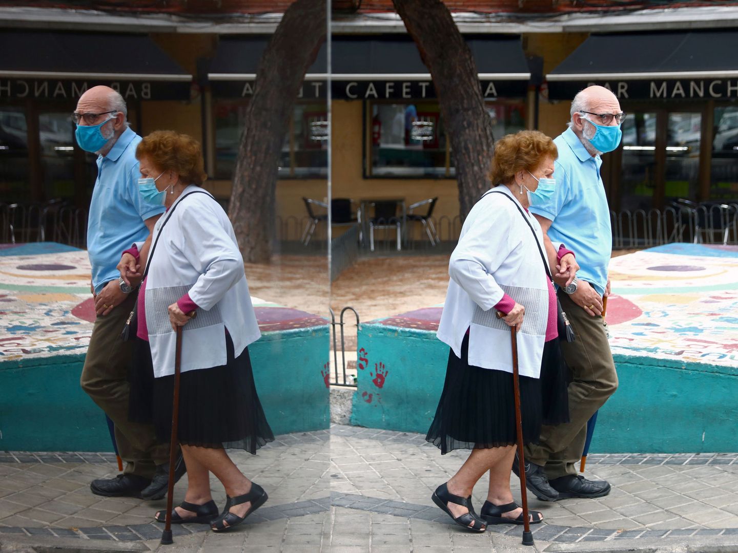Una pareja de ancianos camina por una calle del barrio de Usera, en Madrid. (Reuters)