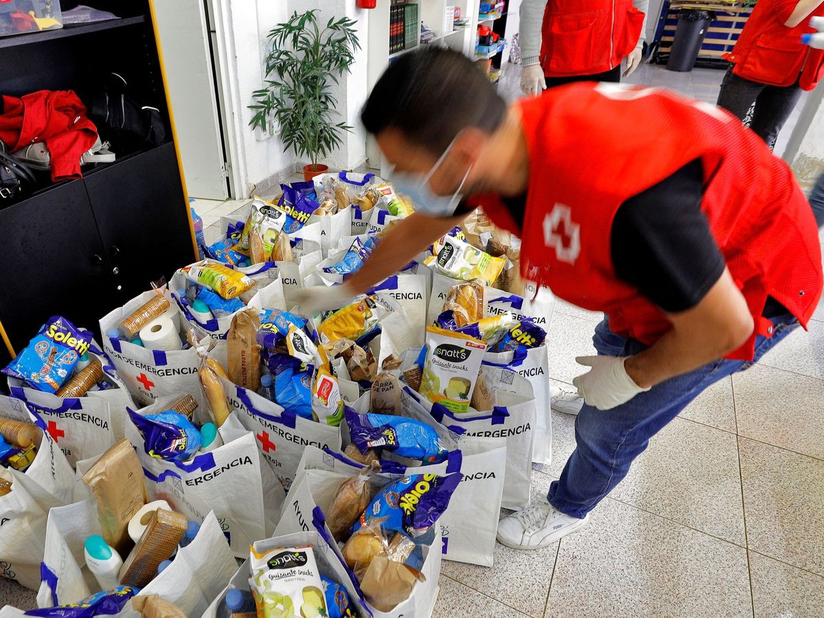 Foto: Un voluntario de Cruz Roja prepara las bolsas con productos de primera necesidad. Foto: EFE Manuel Bruque
