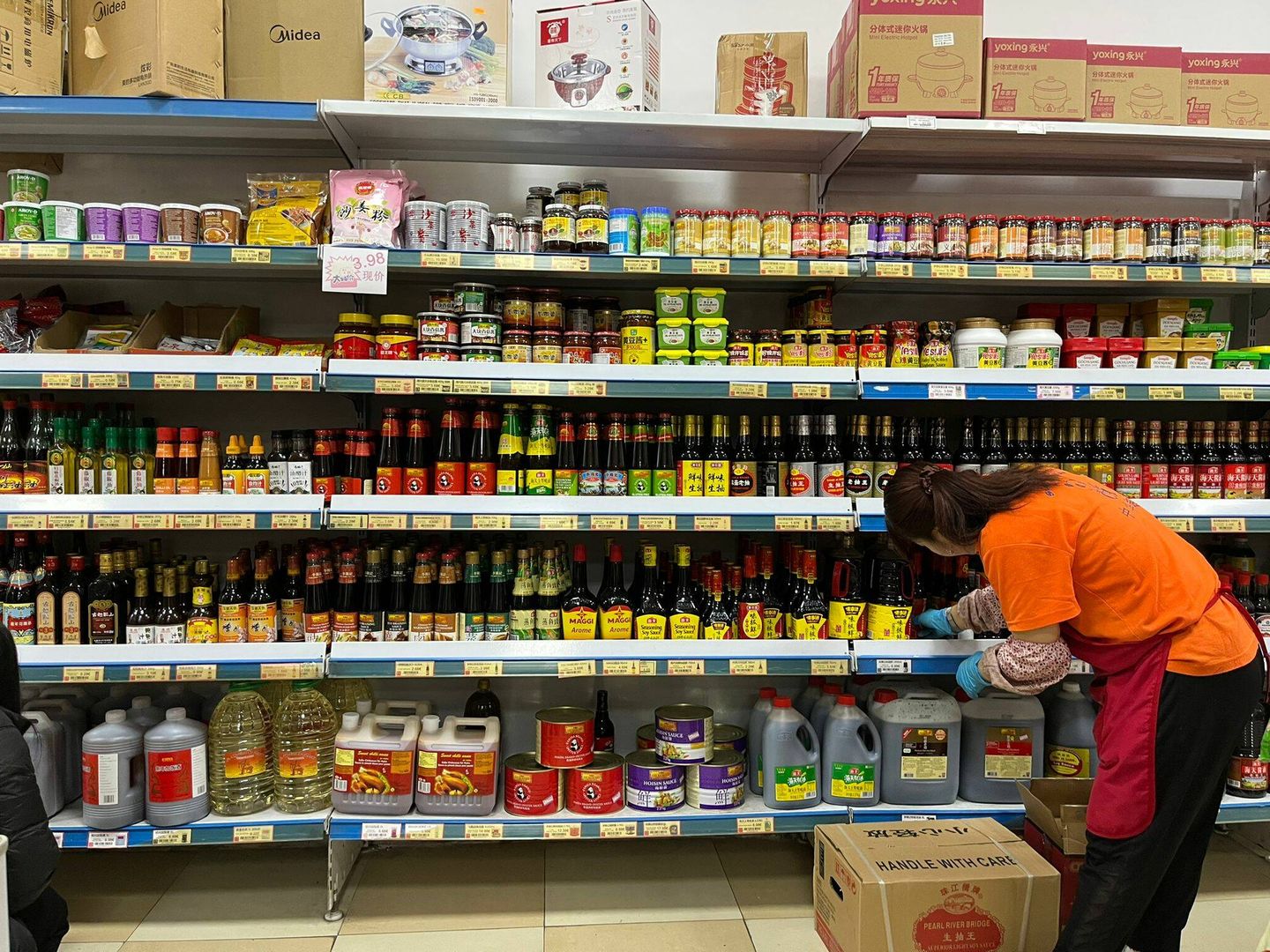 Una mujer, trabajando en un supermercado chino del barrio de Usera. (EFE)