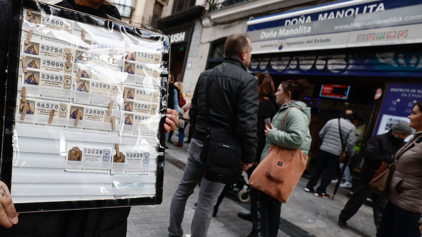 Algunas personas venden décimos de Doña Manolita con recargo frente a la administración (EFE/Sergio Pérez) 