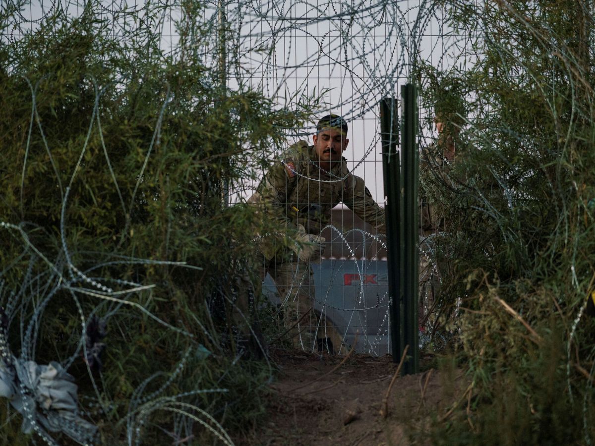 Foto: La Guardia Nacional de Texas repara un muro de alambre en la frontera con México. (Reuters/Paul Ratje)
