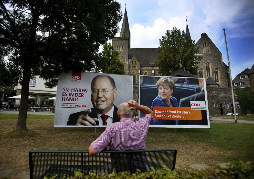Foto: Un hombre observa los carteles electorales de Ángela Merkel (d), de la CDU, y del candidato de la oposición Peer Streinbrück (i), del Partido Socialdemócrata, e