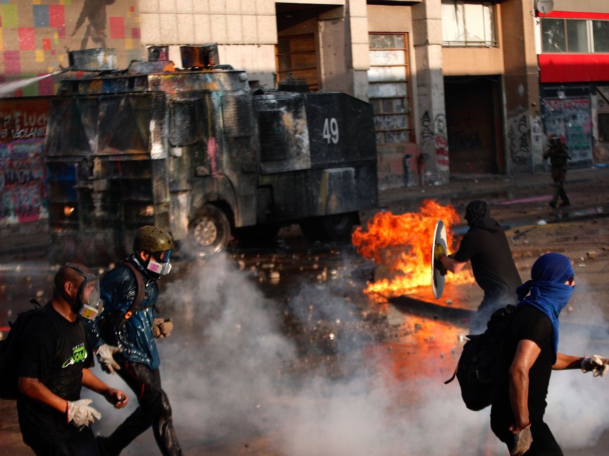 Foto: Manifestantes se enfrentan a las Fuerzas Especiales de Carabineros en los alrededores de la plaza Italia de Santiago (Chile) el viernes pasado. (EFE)
