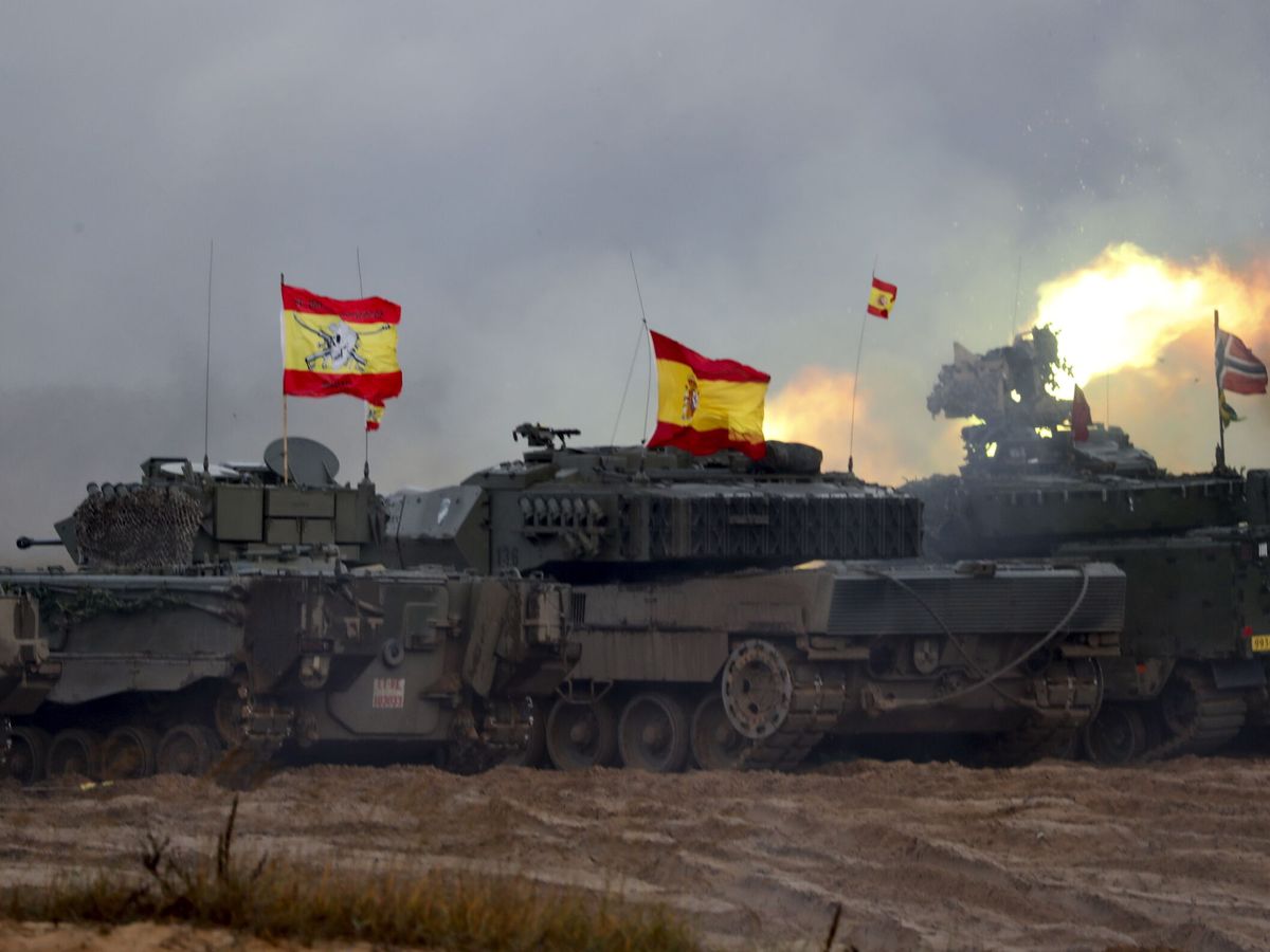 Foto: Militares españoles (i) y británicos, con sus vehículos blindados, asisten al entrenamiento de fuego durante el ejercicio militar. (EFE/Toms Kalnins)