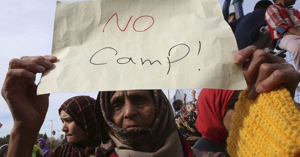 Foto: Una mujer sostiene un papel durante la manifestación en contra del estado de los refugiados en un asentamiento de Grecia. (Reuters)