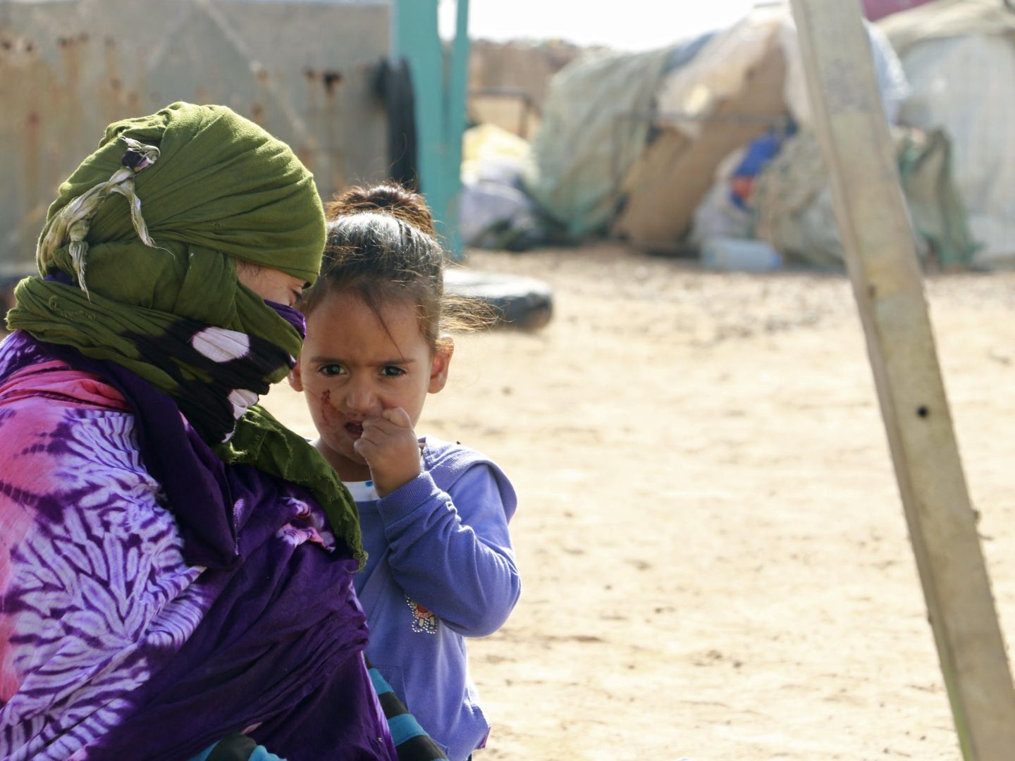 Una madre con su hija a la puerta de su casa en en campo de refugiados saharaui de Auserd (EFE)
