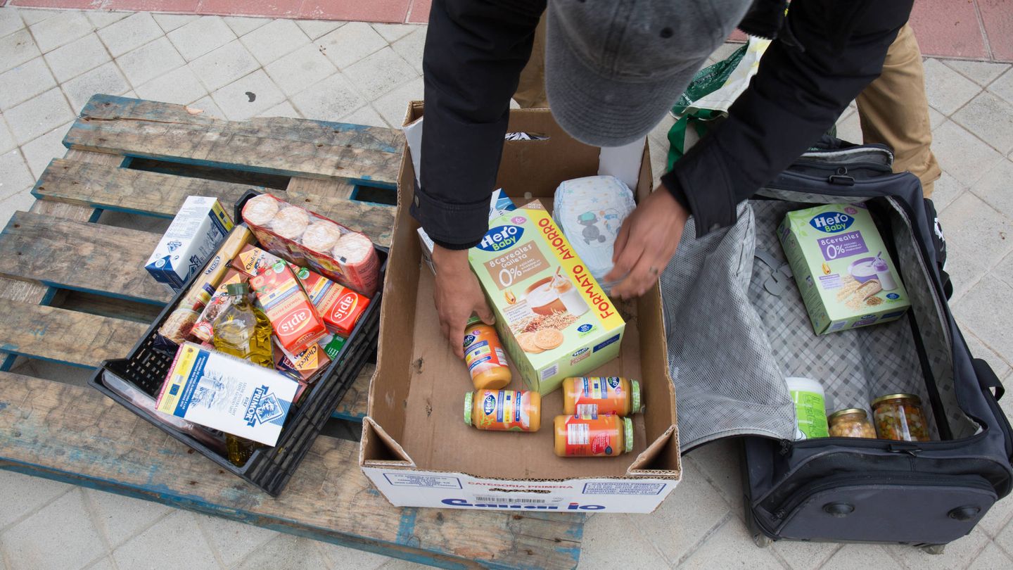 Un hombre llena una maleta con alimentos solidarios. (D.B.)