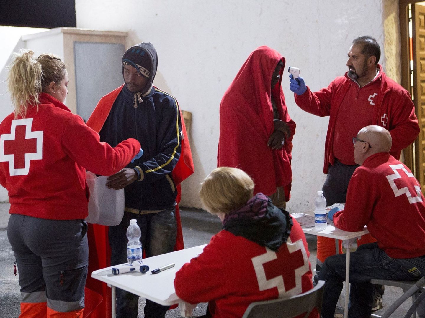 En Granada, miembros de la Cruz Roja atienden a dos inmigrantes rescatados. (EFE)