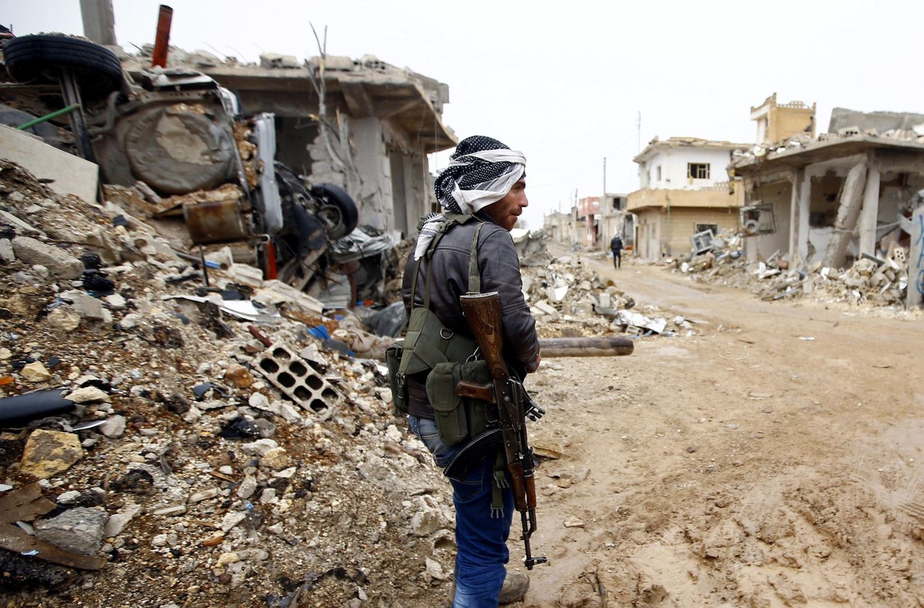 Un combatiente kurdo de las YPG, entre edificios destrozados por los combates en Kobane, norte de Siria. (Reuters)