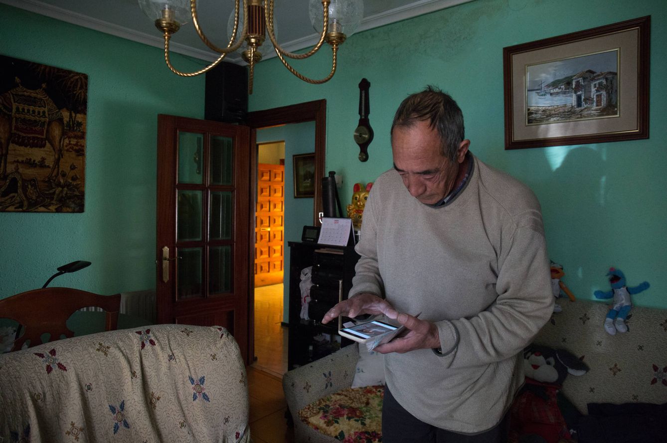 Marcelino observa fotografías de sus hijos en el salón de su vivienda. (D.B.)