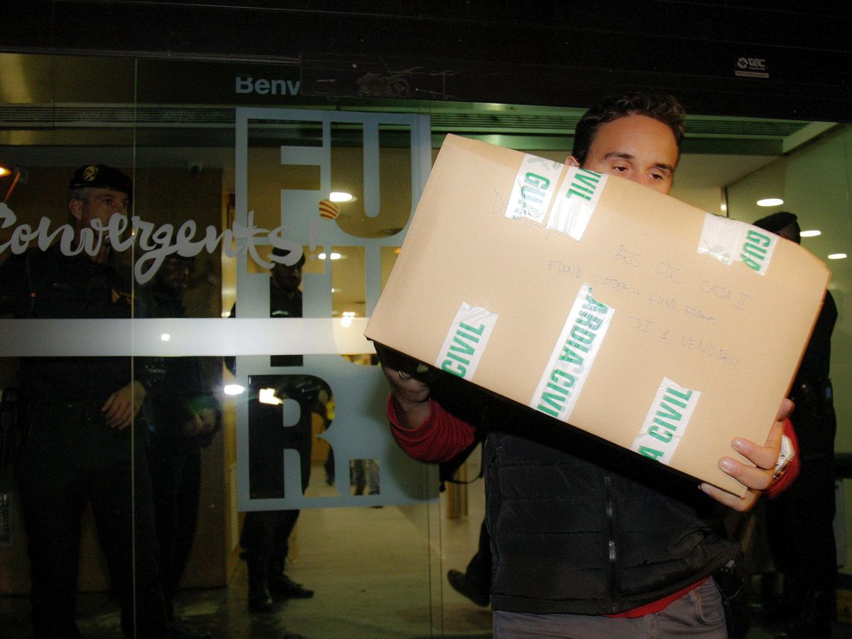 Foto: Agentes de la Guardia Civil sacan de la sede de Convergencia una decena de cajas durante los registros en el caso del 3%. (EFE)