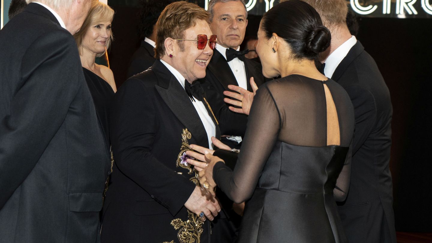 Meghan y Harry, saludando a Elton John en el estreno de 'El rey león'. (Reuters)