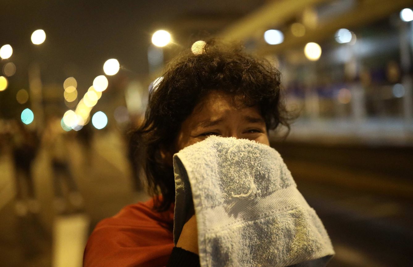 Una manifestante resulta afectada por gases lacrimógenos disparados por la Policía en la Plaza San Martin en Lima durante las protestas de noviembre. (EFE) 