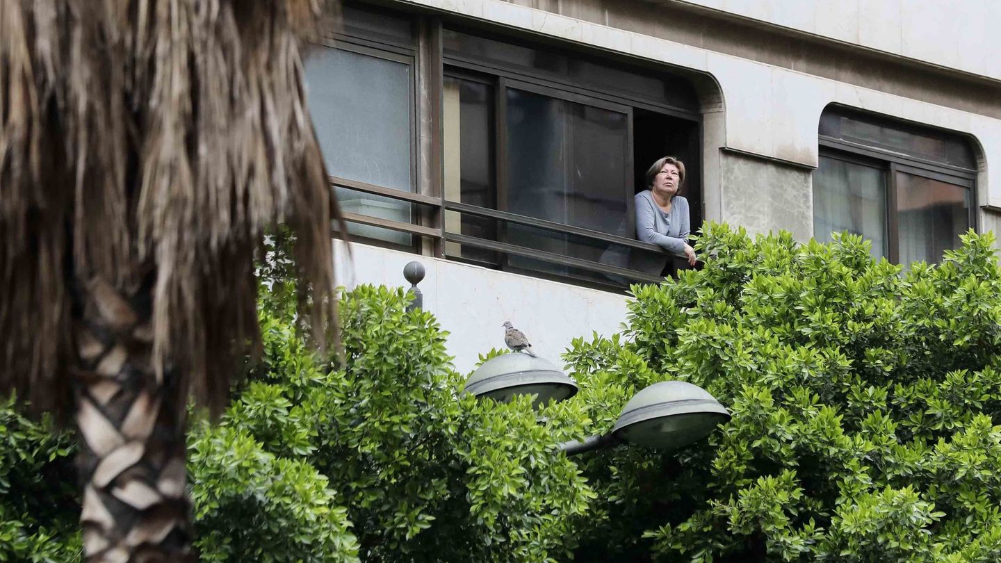 Una vecina, asomada a la ventana de su vivienda en Valencia (EFE)