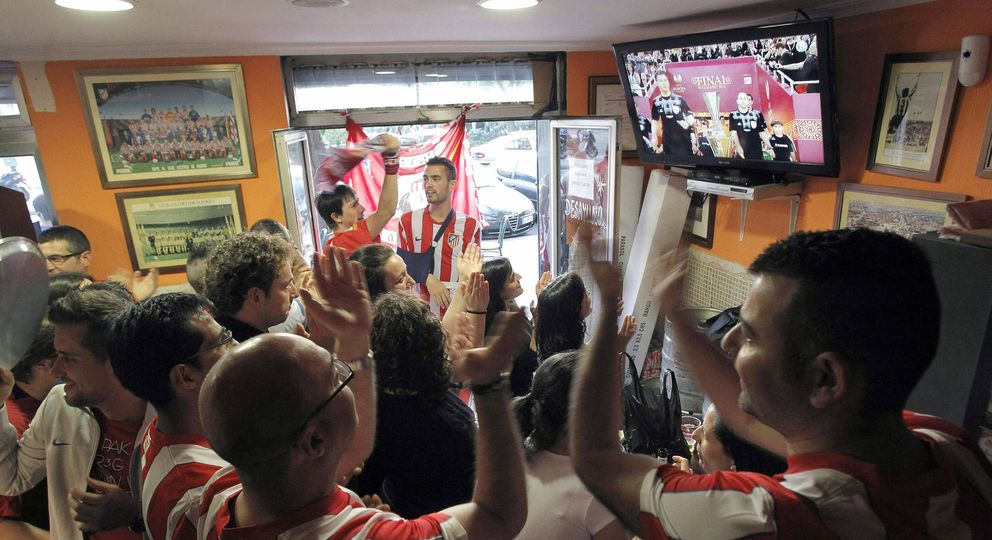 Aficionados del Atlético miran un partido en televisión.