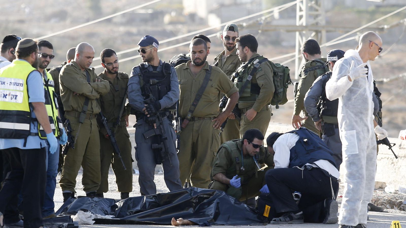 Foto: Varios policías israelíes recopilan pruebas junto al cuerpo sin vida de un palestino que ha sido abatido a tiros por un soldado israelí. (Efe) 