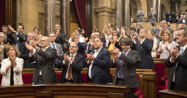 Foto: Carles Puigdemont cruza una mirada cómplice con Carme Forcadell mientras su gabinete aplaude la aprobación de la Ley de Transitoriedad Jurídica. (EFE)