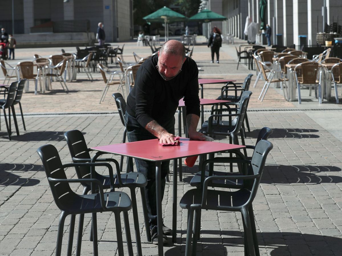 Foto: Un camarero desinfenta la mesa de una terraza. (EFE)